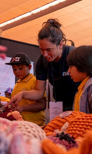 La investigadora de Núcleo NUTME, Celeste Kroeger, le muestra a unos niños la exposición